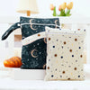A pair of navy blue and cream waterproof wet dry bags with floral and celestial patterns are displayed on a white surface.