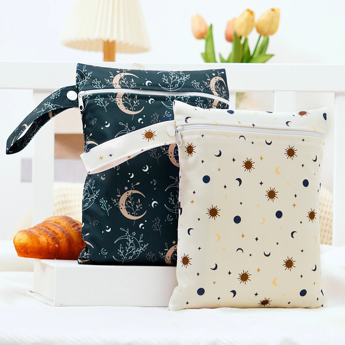 A pair of navy blue and cream waterproof wet dry bags with floral and celestial patterns are displayed on a white surface.