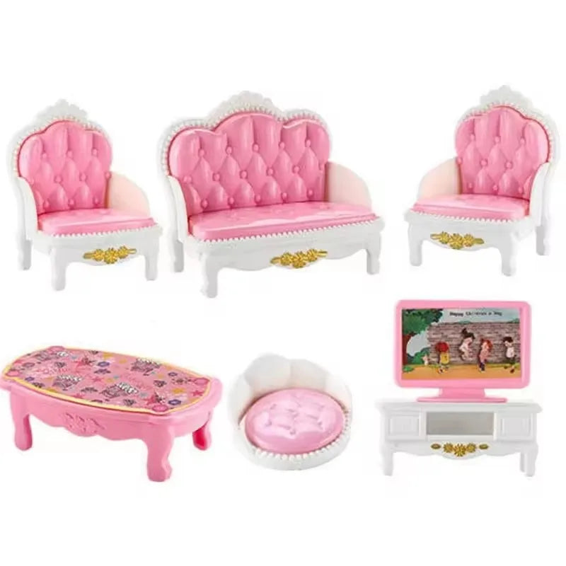 A set of pink and white miniature dollhouse furniture including a sofa, chairs, and a bed.