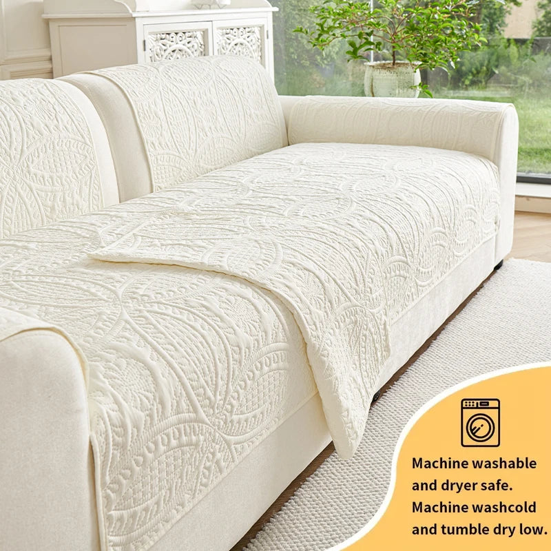 A cream anti-slip sofa cover is shown draped over a light-colored sofa, highlighting its textured, quilted surface.