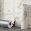 Roll of silver 3D marble peel-and-stick waterproof wall panels against a white marble background.