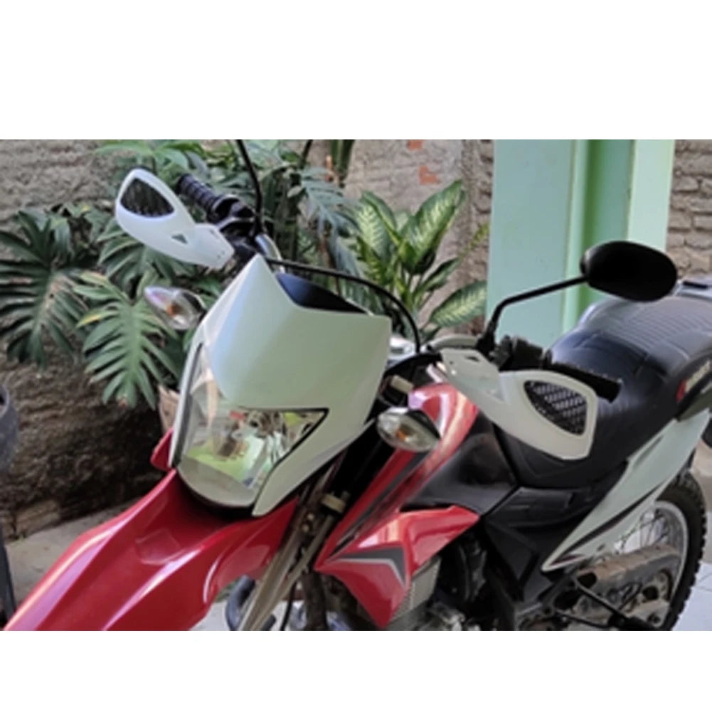 A close-up of a red and black motorcycle equipped with white hand guards and windproof nylon shields.