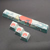 A long, rectangular PBT keycap featuring a design of waves and a rising sun in coral sea colors.