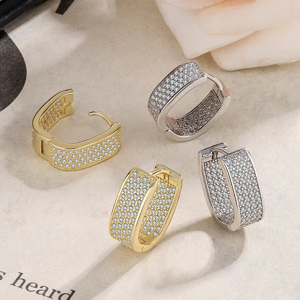 Un ensemble de boucles d'oreilles à diamants en argent 14K, montées sur une fondation claire.