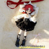 A female BJD doll wearing a black and white maid dress outfit with red hair and a red ribbon.