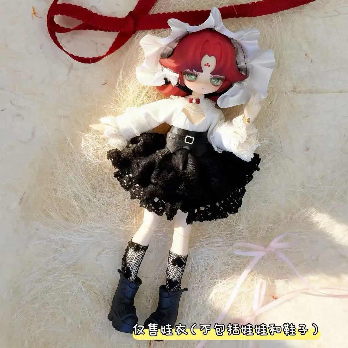 A female BJD doll wearing a black and white maid dress outfit with red hair and a red ribbon.