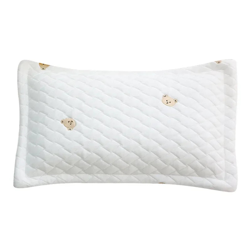 White quilted baby pillow with small bear embroidery