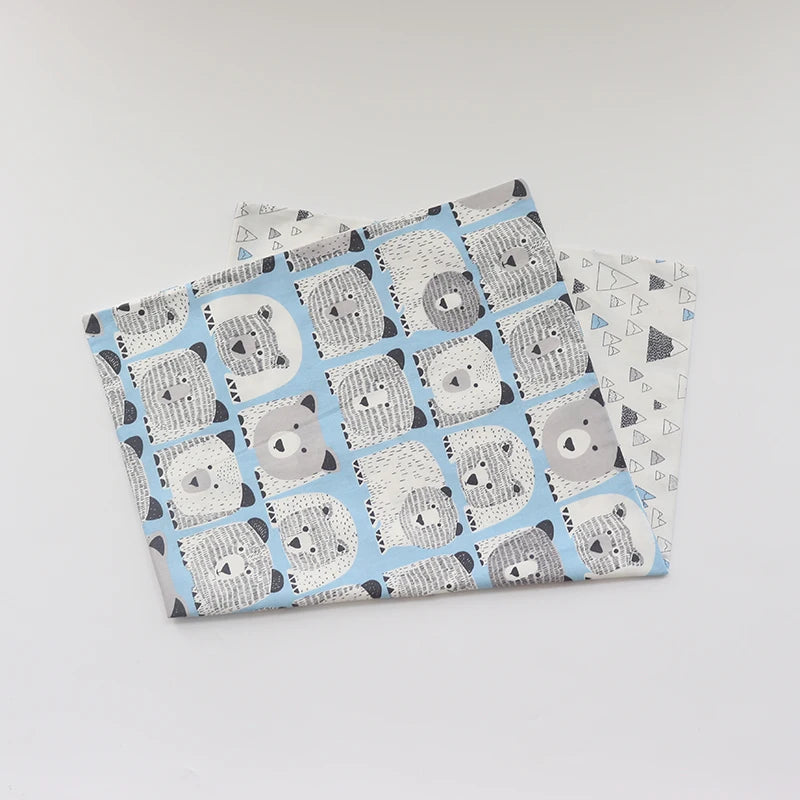 A stack of soft cotton baby pillowcases featuring a repeating pattern of gray and white cartoon pandas on a light blue backgr