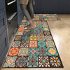 A rectangular floor mat featuring a colorful geometric pattern of floral and abstract designs on a light wood floor.