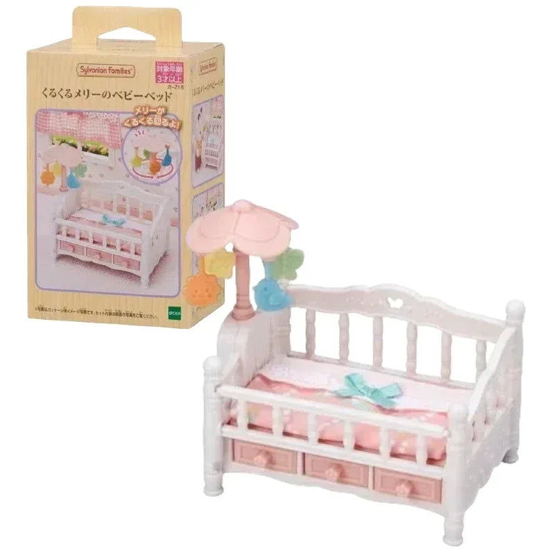 A wooden crib and pink accessories from a Sylvanian Families Forest Friends gift set.