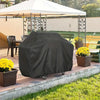 A dark gray heavy duty waterproof grill cover is placed on a brick patio next to potted yellow flowers.