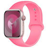 A pink silicone sport band worn around a silver Apple Watch.