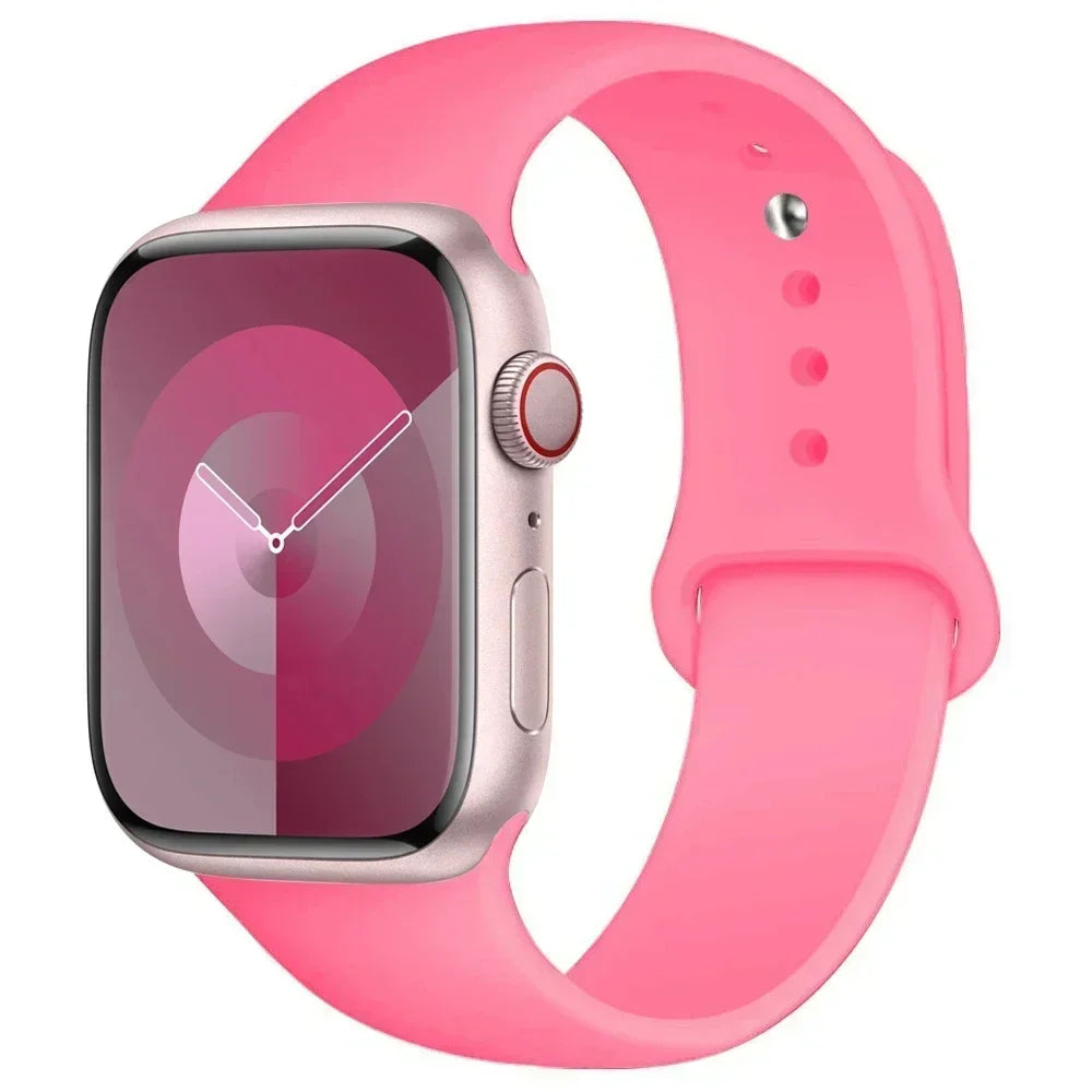A pink silicone sport band worn around a silver Apple Watch.