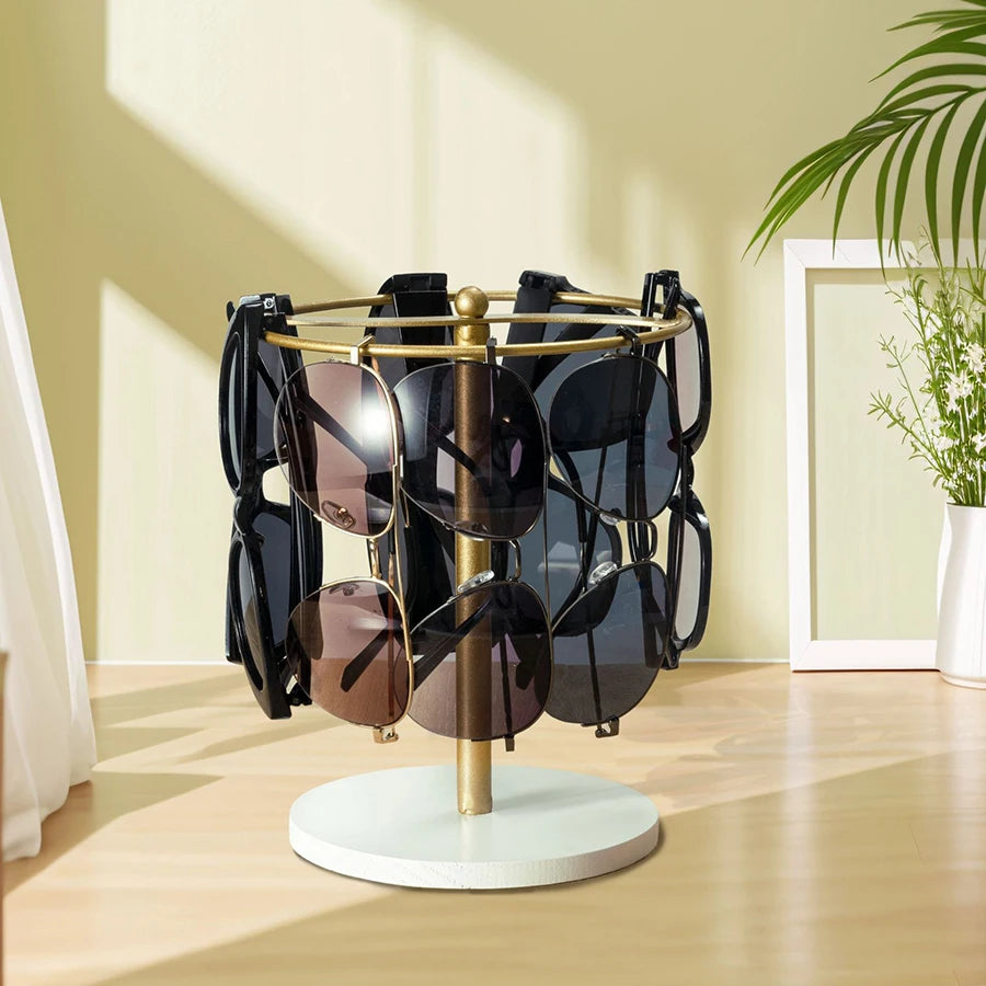 A gold-toned stand with a wooden base organizes twelve pairs of sunglasses in a display setting.