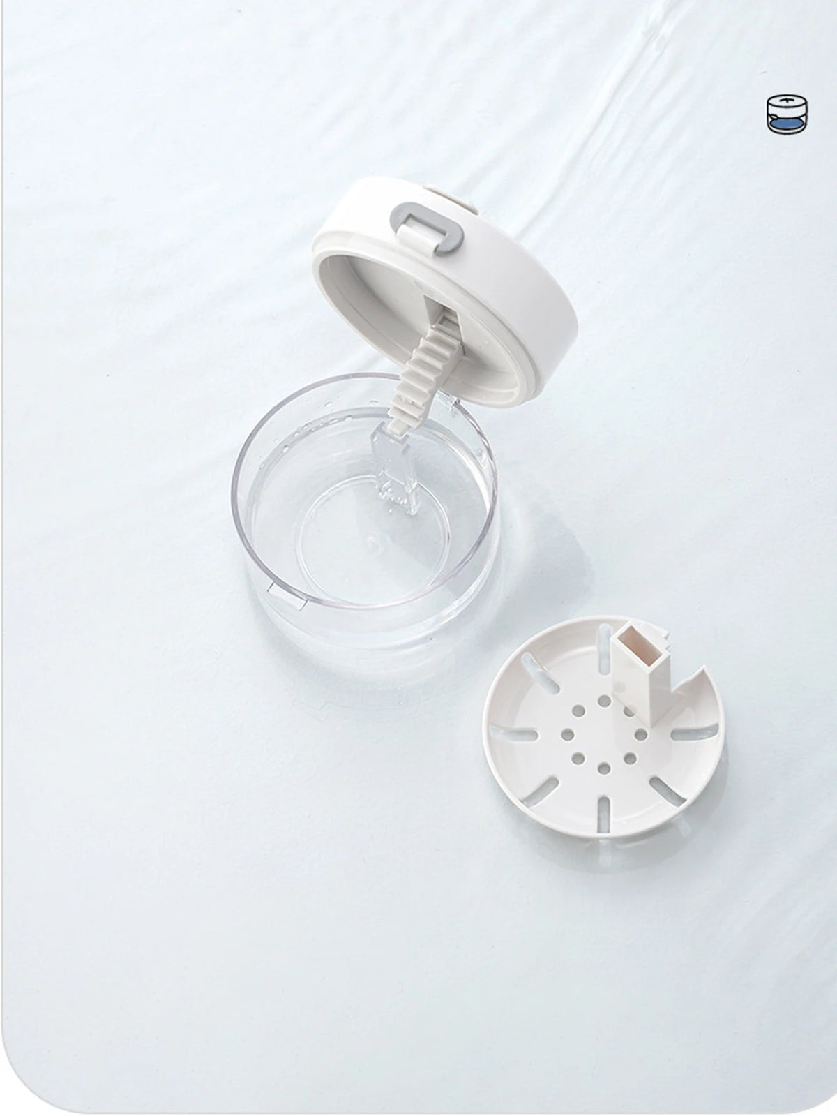 A white portable denture case with a cleaning brush storage mechanism is shown on a white surface.