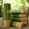 A stack of green and brown citronella incense sticks standing upright on a wooden surface.