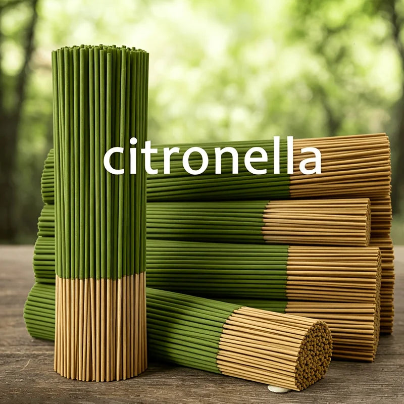 A stack of green and brown citronella incense sticks standing upright on a wooden surface.