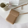 A tan vintage PU leather crossbody shoulder bag resting on a white surface next to a mug and a calendar.