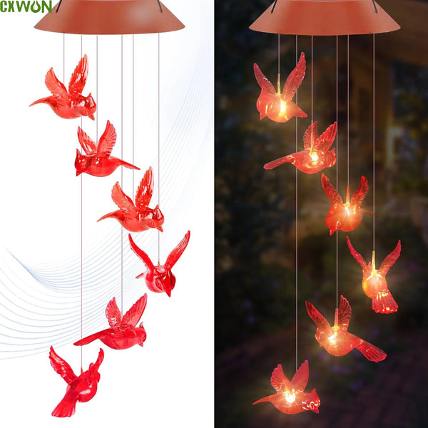 A cluster of red cardinal wind chimes with LED lights hanging from a fixture.