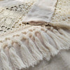 Beige sheer curtain fabric featuring delicate eyelet lace and fringe tassels