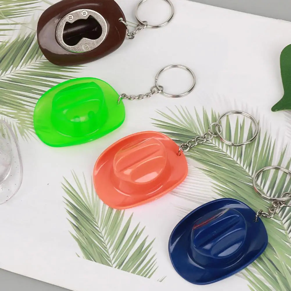 A set of three colored cowboy hat bottle opener keychains, including brown, green, and orange, displayed on a white surface w