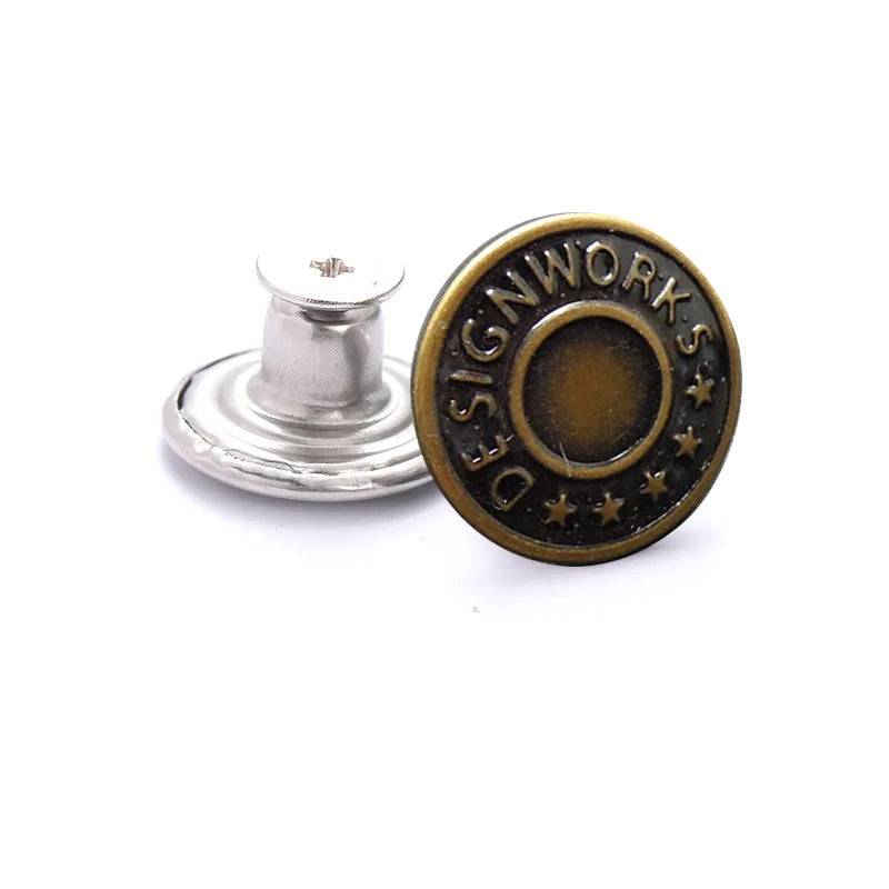 A round brass button with the engraved text DESIGNWORKS and a silver mounting base.