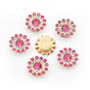 A collection of pink and clear rhinestone flowers, some set in gold-toned metal, arranged on a white background.