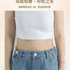 A close-up of a woman wearing a white crop top and blue jeans, demonstrating the effect of a two-sided tightening product.