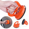 Orange heavy duty car dent puller kit with two suction cups being used on a car surface.