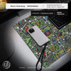 A white smartphone rests on a green and gray city road design mouse pad next to a laptop.