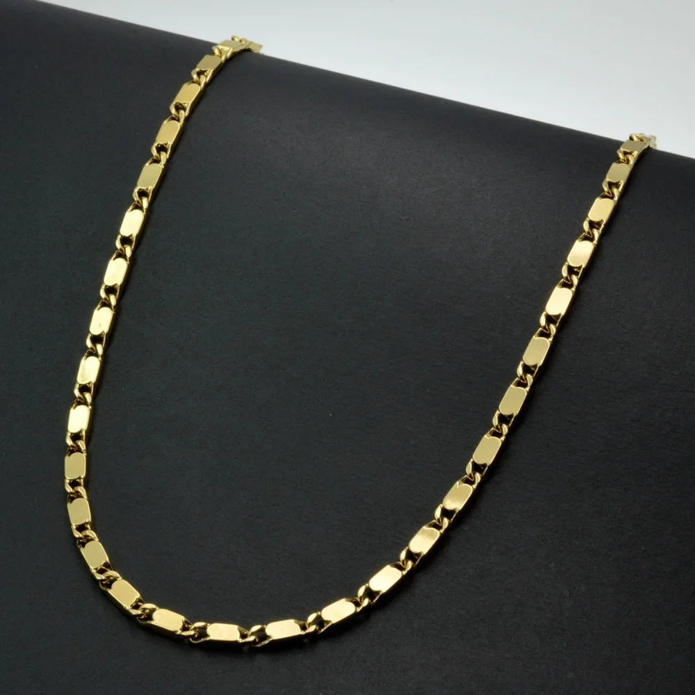 A gold-plated Cuban link chain necklace displayed against a dark background.