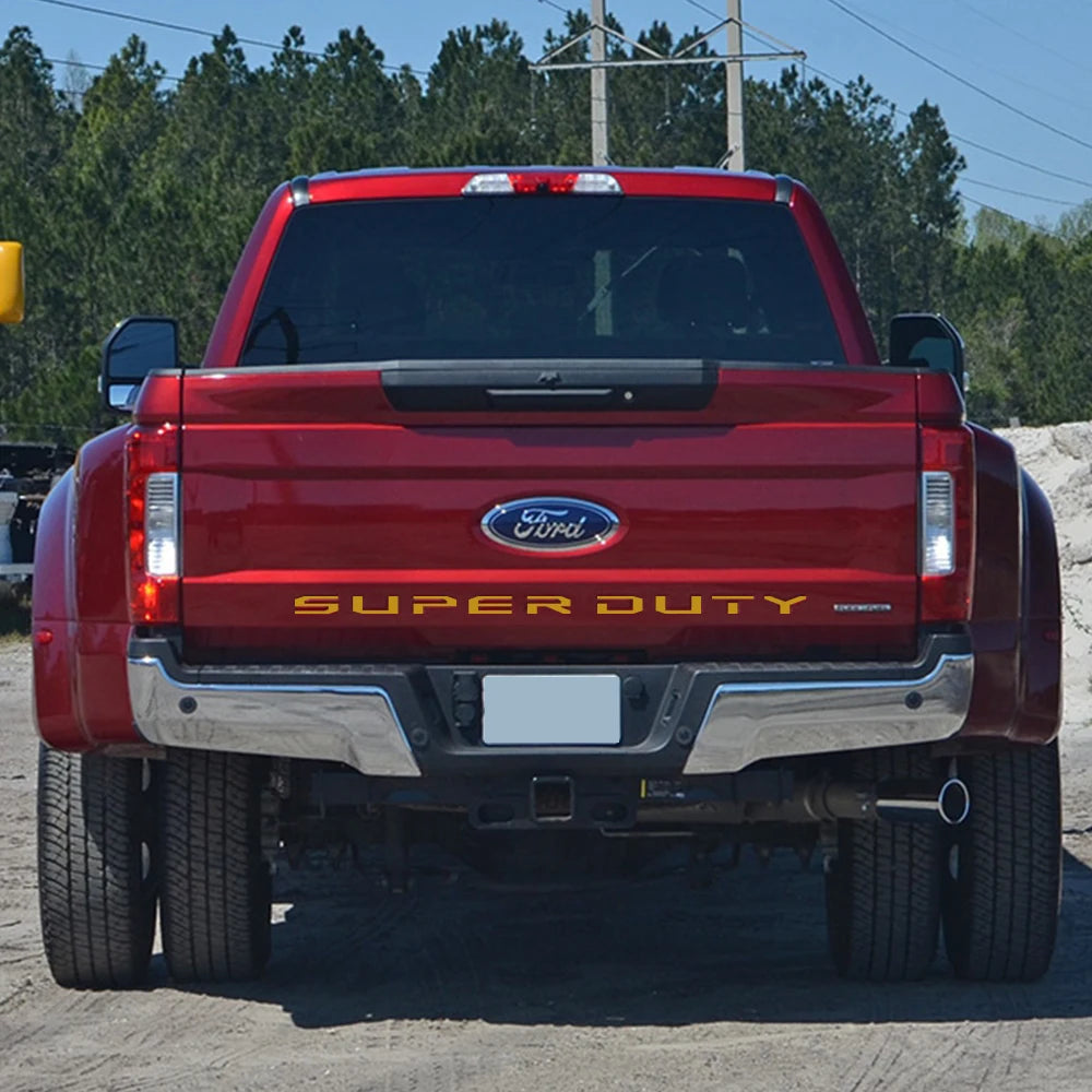 Rear view of a red Ford Super Duty pickup truck with a tailgate insert decal.