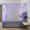 A bedroom featuring a bed draped with a purple lace canopy mosquito net over the bedding.