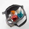 A gray mesh hanging toiletry bag filled with various toiletries including a soap bottle and a brush.