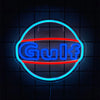 A neon sign shaped like a truck with the word Gulf illuminated in blue and red light against a dark background.