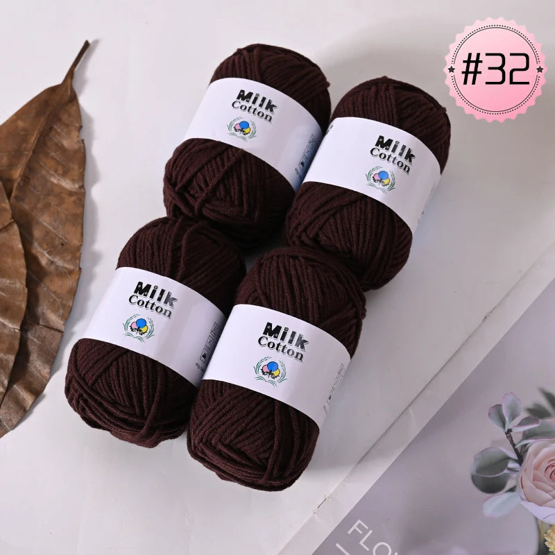 Three skeins of dark brown Milk Cotton yarn with white labels are displayed on a white surface.