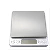 A silver digital pocket scale with a tray and display screen.