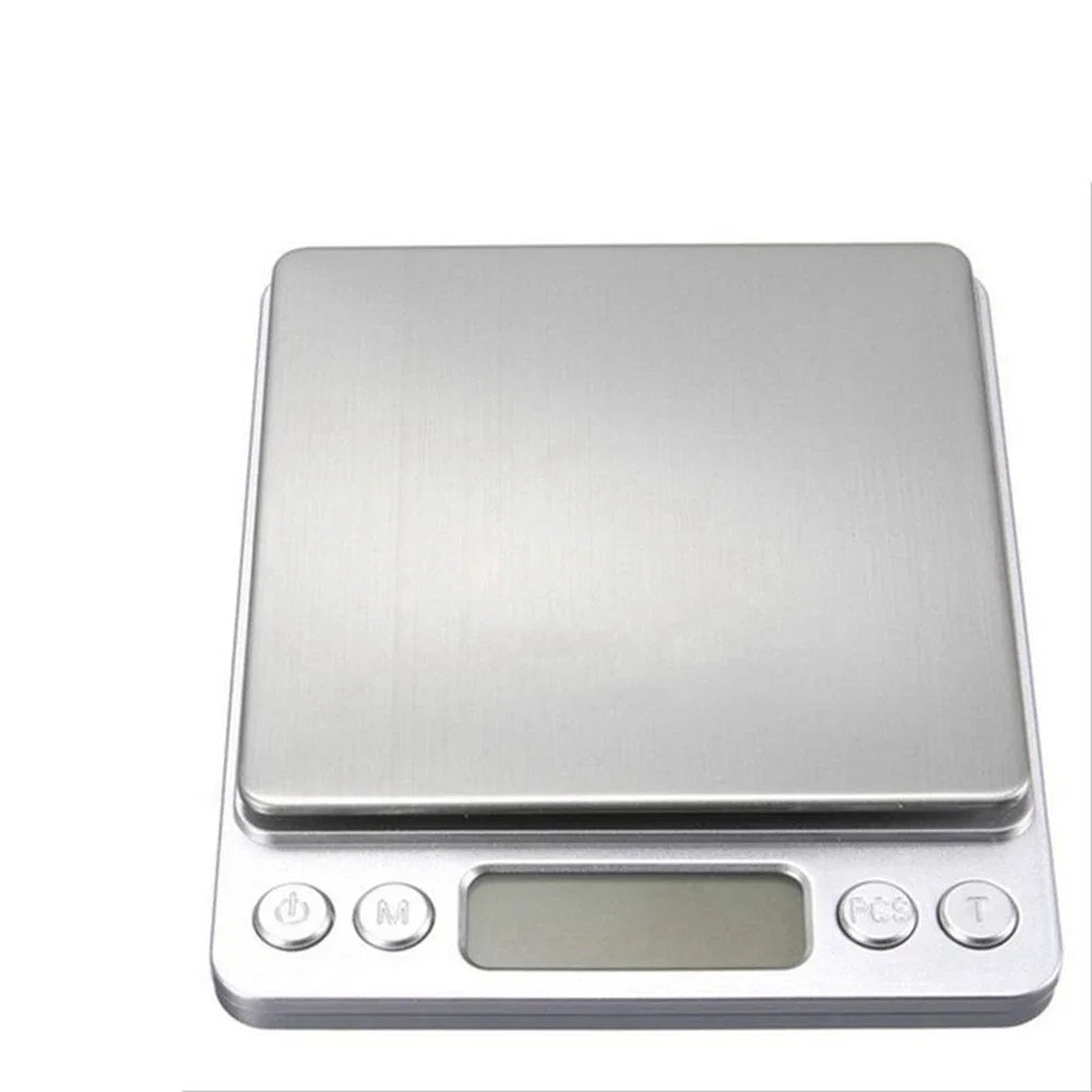 A silver digital pocket scale with a tray and display screen.
