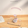 A clear acrylic tablet stand with a pink silicone base and grooves for anti-slip reinforcement.
