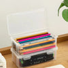 Clear plastic storage box with a lid filled with colored pencils and other art supplies
