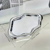 A silver cloud-shaped jewelry tray is shown on a white surface.