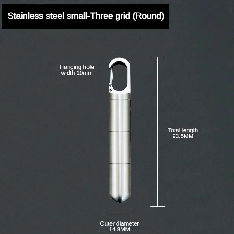 A stainless steel small three grid round hanging hole pill capsule with a keychain.