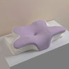 A light purple ergonomic memory foam cervical pillow resting on a white surface.