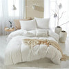 A white duvet cover set with pom tassels and soft microfiber bedding displayed on a bed.