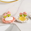 A set of ceramic soap dishes featuring pink and yellow tulips for drainage soap.