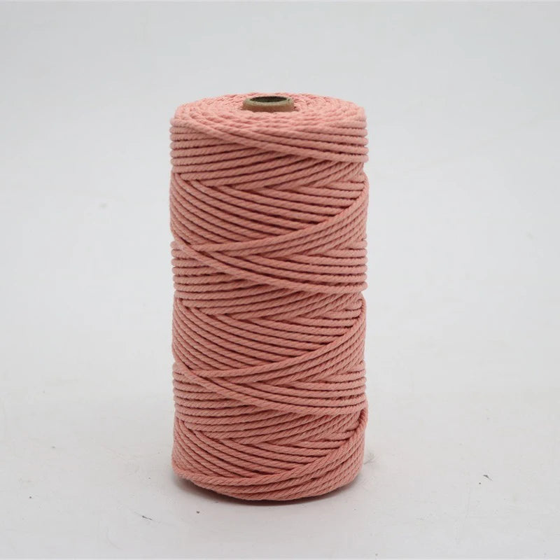 A spool of pink macrame cord, 3mm/4mm thickness, used for crafting.
