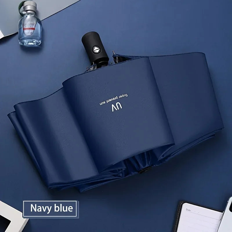 Navy blue automatic compact umbrella with a clear glass bottle nearby.