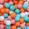 A close-up view of a large pack of colorful plastic balls in various shades of orange, pink, and blue.