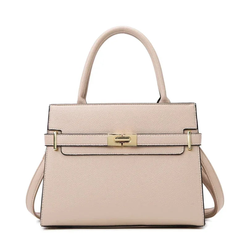 A pale pink leather handbag with a gold clasp and matching coin purse.