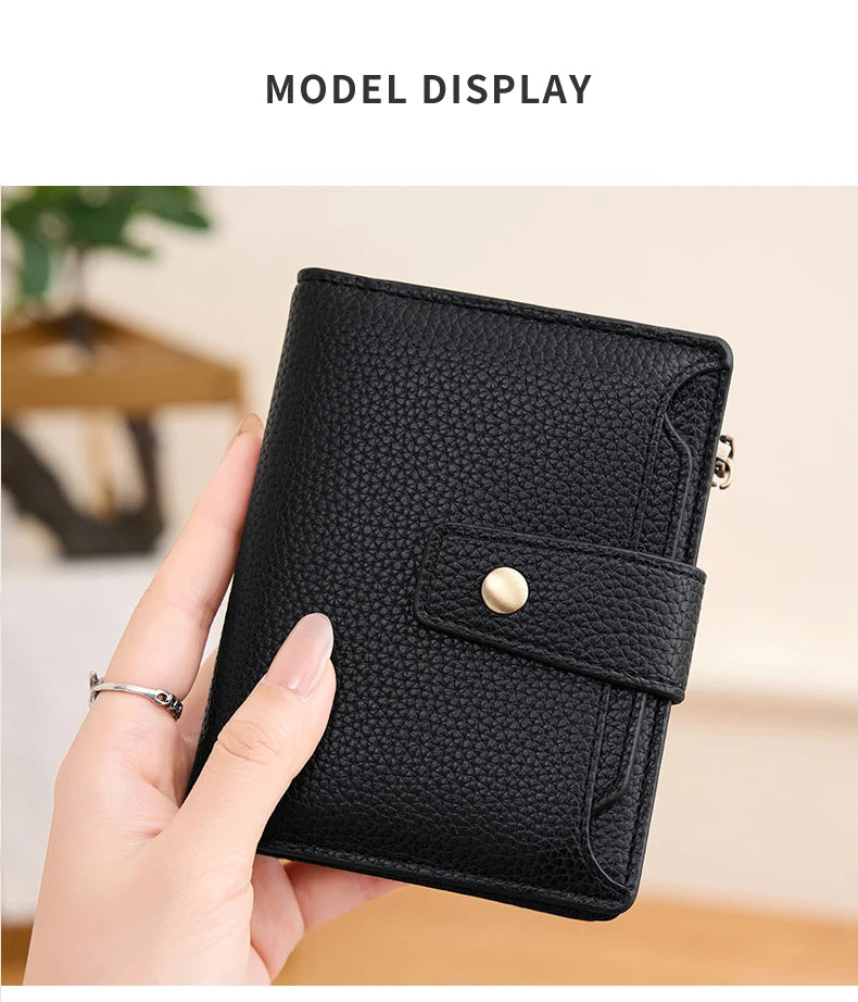A hand holds a black compact RFID-blocking bi-fold wallet displaying its texture and closure.
